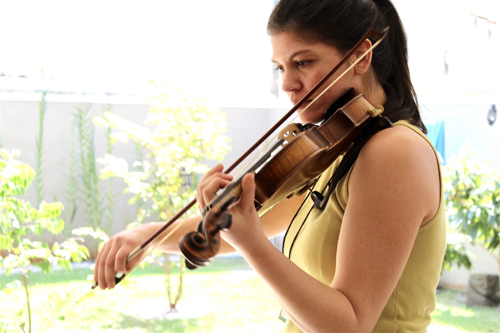 Aluna tocando violino ao ar livre